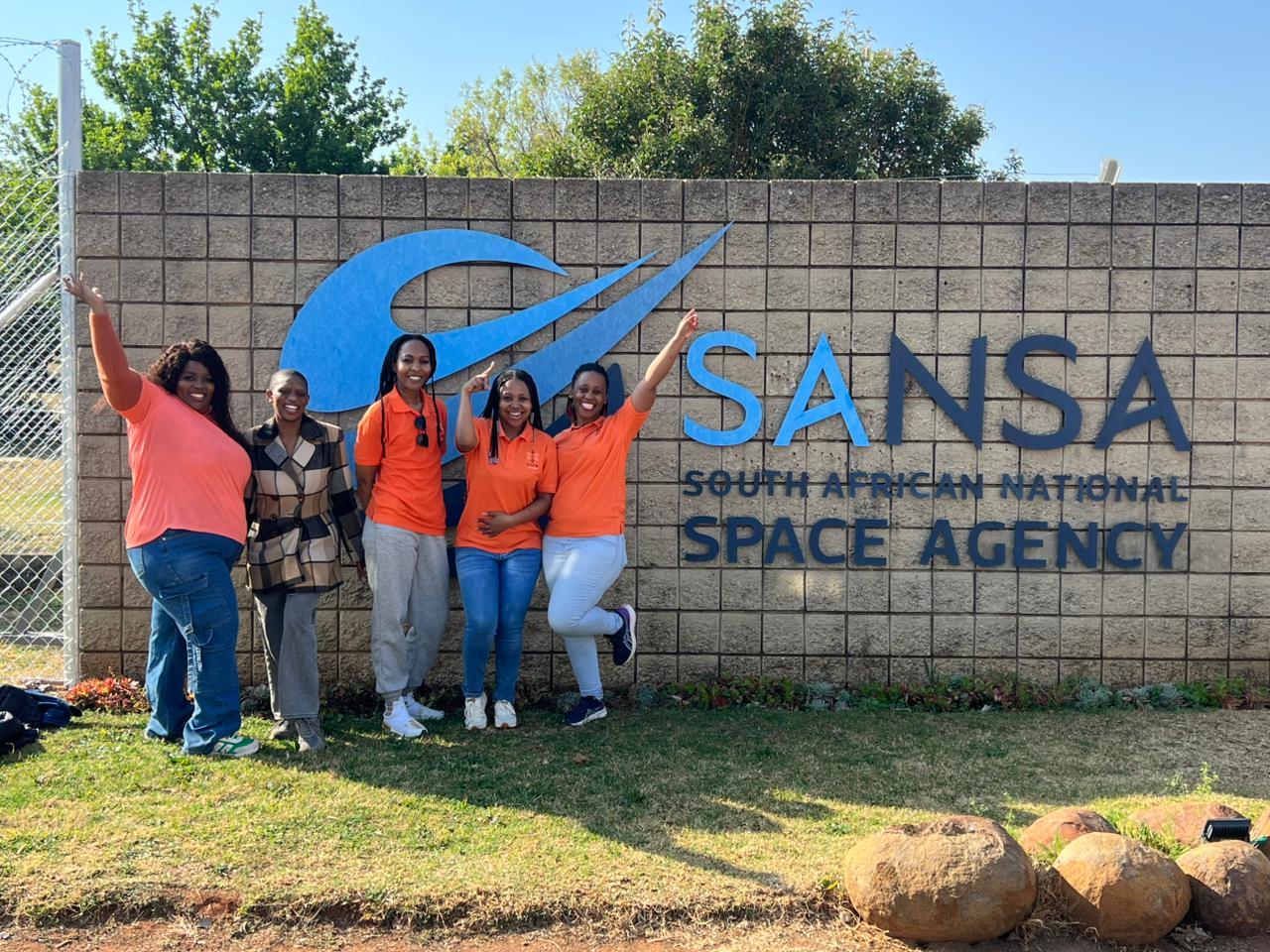 STEM Ignited team members standing in front of the South African National Space Agency SANSA sign.